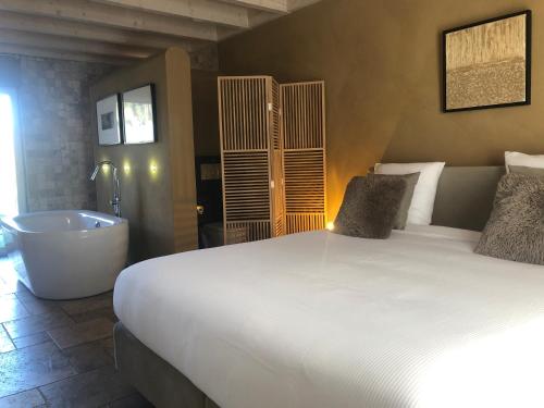 ein Schlafzimmer mit einem Bett und einer Badewanne sowie einem Bett und einer Badewanne in der Unterkunft Le champ Madame in Stavelot