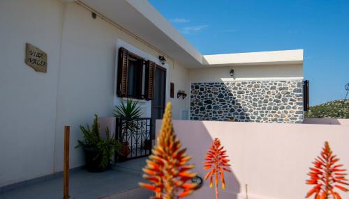 Biały dom z drzwiami i roślinami w obiekcie Villa Valia- Relaxation and Cretan hospitality w Jerapetrze