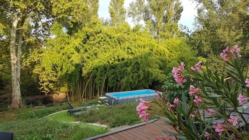 una piscina en un jardín con árboles y flores en les Crozes Petit, en Revel