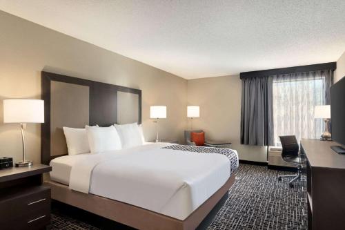 een hotelkamer met een groot bed en een bureau bij La Quinta Inn & Suites by Wyndham St Louis Route 66 in Saint Louis