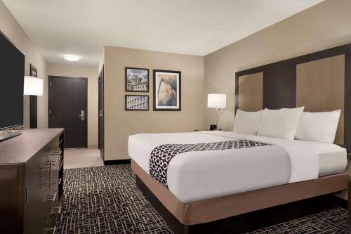 a hotel room with a large bed and a bathroom at La Quinta Inn & Suites by Wyndham St Louis Route 66 in Saint Louis