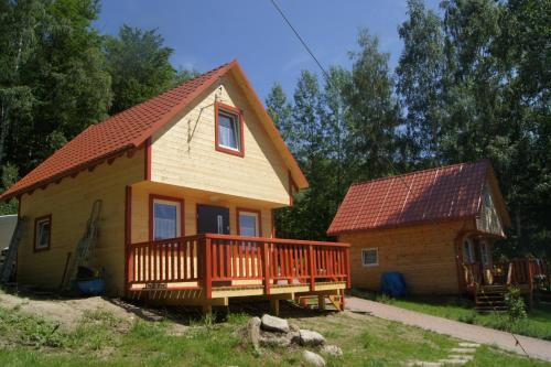 a small house with a large deck next to a building at Grzywaczówka in Przesieka