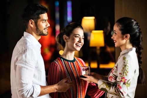 a man and two women standing next to each other at Novotel Chennai OMR in Chennai