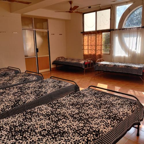 a room with two beds and two windows at Bedspace Living in Udupi