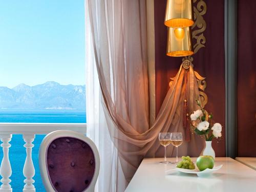 een kamer met een tafel met wijnglazen en een raam bij La Boutique Hotel & Suites - Adults Only in Antalya
