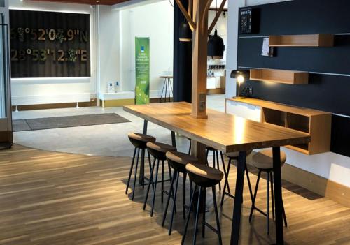 a dining room with a wooden table and stools at Original Sokos Hotel Seurahuone Savonlinna in Savonlinna