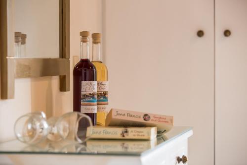 two bottles of wine and books on a glass shelf at Elleana south Corfu in Agios Georgios