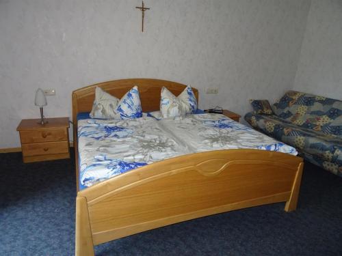 a bedroom with a wooden bed with a cross on the wall at Ferienwohnung Wehner in Seiferts