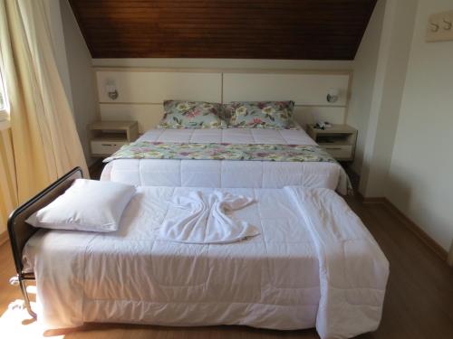 a bedroom with a bed with a towel on it at Olidal Pousada da Serra in Gramado