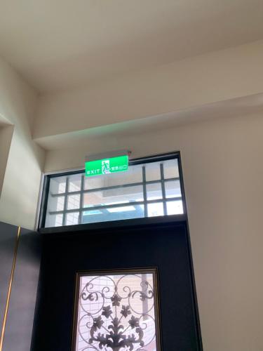 a green street sign above the door of a building at AwIN’s Homestay in Ruisui