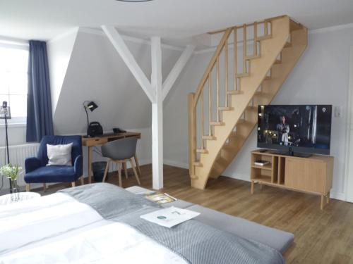 1 dormitorio con cama, escritorio y escalera en Hotel Witthus GmbH & CoKG, en Greetsiel
