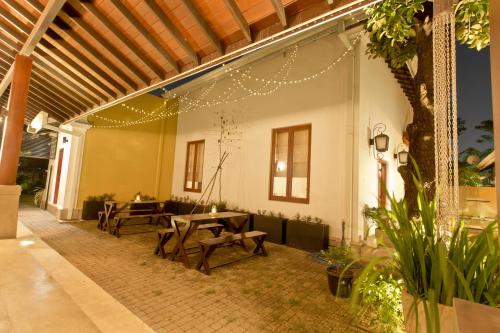 a patio with tables and benches in a building at Swanee Grand in Negombo