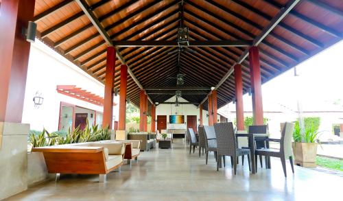 a restaurant with chairs and tables and a ceiling at Swanee Grand in Negombo
