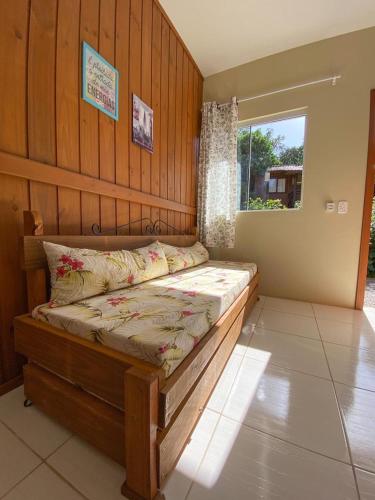 a bed in a room with a window at Recanto Marina in Guarda do Embaú