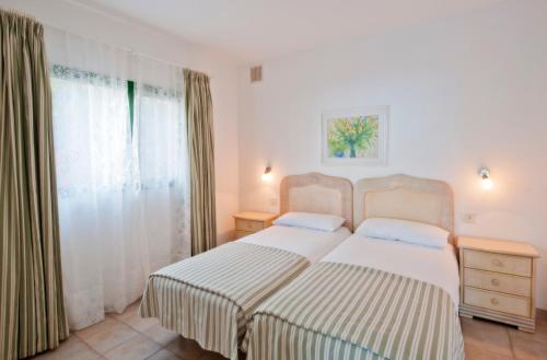 Los Barros的住宿－Villa Verde Superior，一间卧室设有两张床和窗户。