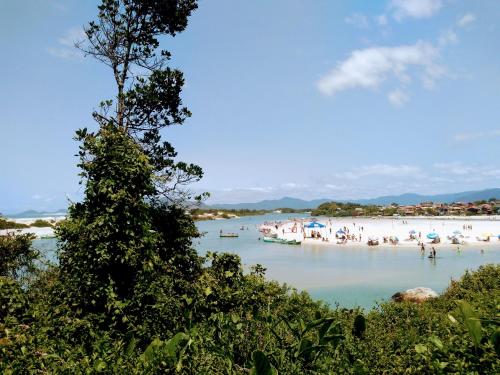 a group of people on a beach in the water at Recanto Marina in Guarda do Embaú