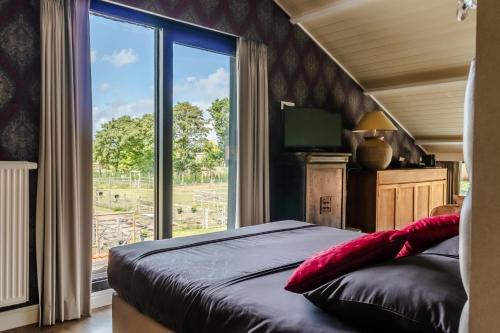 a bedroom with a bed and a large window at Hoeve Chartreuse in Bruges