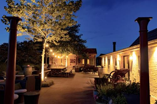 a patio with a tree and lights on a building at Hoeve Chartreuse in Bruges