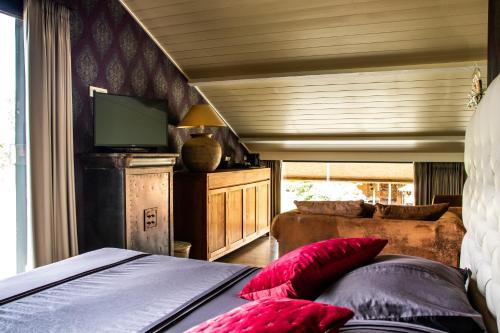 a bedroom with a bed with red pillows at Hoeve Chartreuse in Bruges