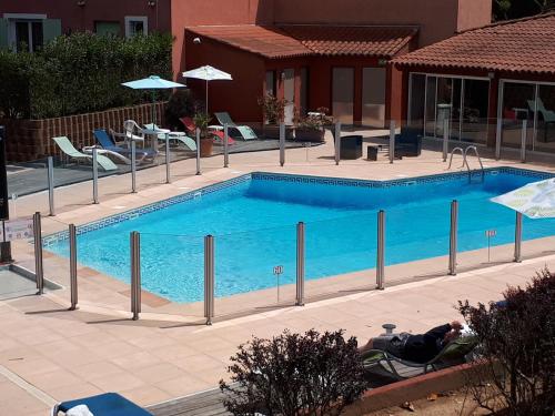 un homme assis dans une chaise à côté d'une piscine dans l'établissement Hotel Albatros, à Mouans-Sartoux