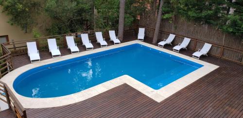 una piscina en una terraza con sillas y una piscina en Sintra Aparts en Mar de las Pampas