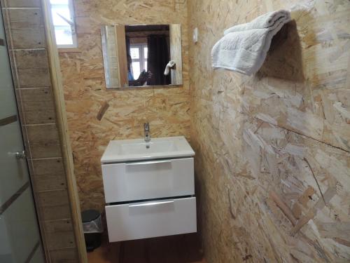 a bathroom with a sink and a stone wall at Chalet charmant à Bouillante avec piscine partagée in Bouillante
