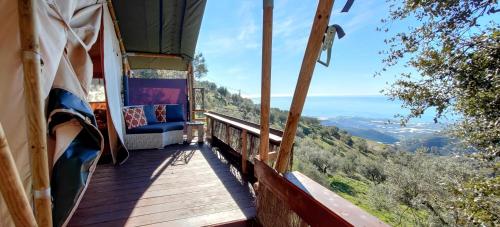 un balcón de una casa con vistas a las montañas en Campo Agave Luxury Tents en Sayalonga