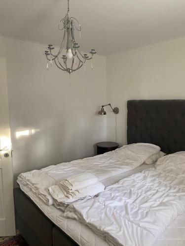 an unmade bed with a chandelier in a bedroom at Varijlyan höger in Sälen