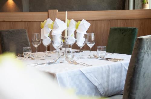 einen Tisch mit Weingläsern und Blumen darauf in der Unterkunft Hotel Eller in Sulden