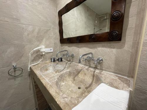 La salle de bains est pourvue d'un lavabo et d'un miroir. dans l'établissement Hotel Mas Palou, à Roses