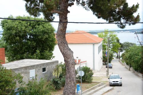 ein Auto, das auf einer Straße neben einem Haus parkt in der Unterkunft Apartmani Nina in Tkon