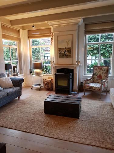 a living room with a couch and a fireplace at "Het Steechje" in Ie bij Schiermonnikoog en Ameland in Ee