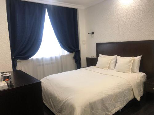 モスクワにあるNab Hotel Taganskayaのベッドルーム1室(青いカーテン、窓付)
