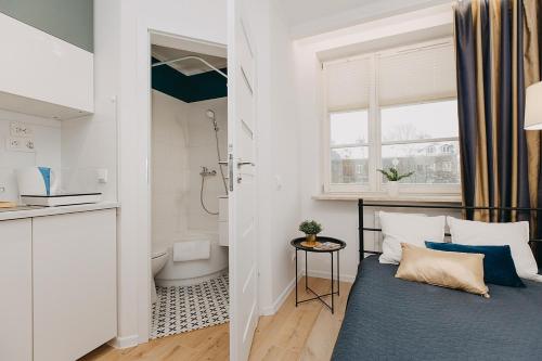 a bedroom with a bed and a bathroom with a shower at Stadion Narodowy Warszawa UNIT ApartmentMini noclegi Super lokalizacja przy Metro MiniStudio with private banthroom in Warsaw