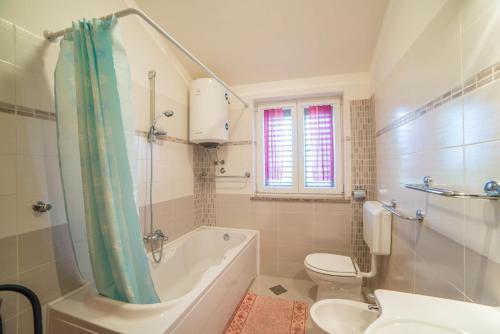 a bathroom with a tub and a toilet and a sink at Apartment Andrea 329 in Vodnjan