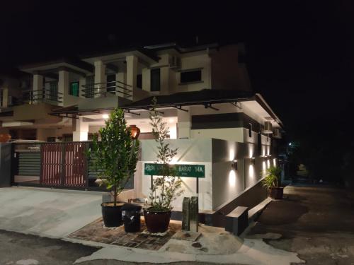 a building with plants in front of it at night at Just Austin Guesthouse in Ipoh