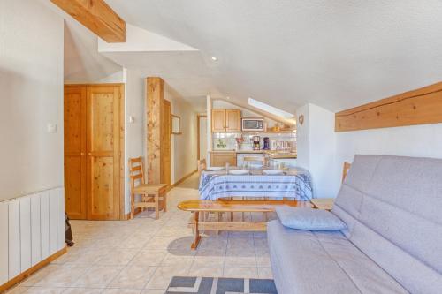 un salon avec un canapé et une table dans l'établissement Schuss 2 - Appartement 2 chambres - Val d'Arly, à Flumet