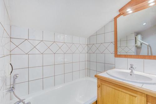 a bathroom with a bath tub and a sink at Schuss 2 - Appartement 2 chambres - Val d'Arly in Flumet