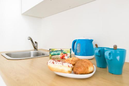 a plate of doughnuts and croissants on a kitchen counter at Crystal Downtown Apartments in Budapest