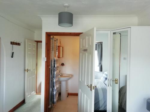 a hallway with a bathroom and a sink at Rockville Amlwch LL68 0TE, UK Apartment in Llanfflewyn