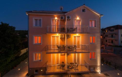 a large white building with people sitting on the balcony at Apartments Island Beat in Supetar
