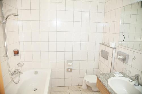 a bathroom with a tub and a toilet and a sink at Hotel Lonac in Duisburg