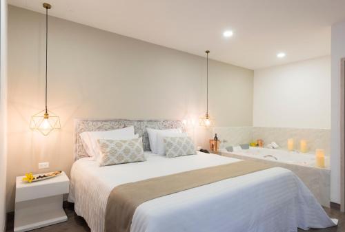 a bedroom with a large bed and a bath tub at Medellín Vibes Hostel in Medellín