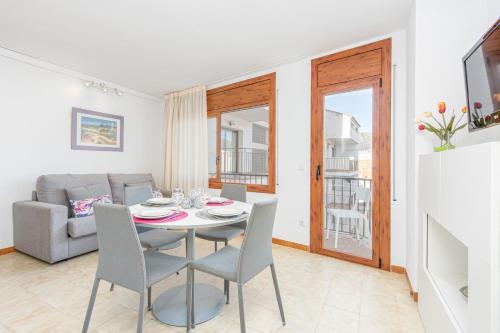 a dining room with a table and chairs and a couch at Apart-rent Apartment Av Rhode 3º 2008 in Roses