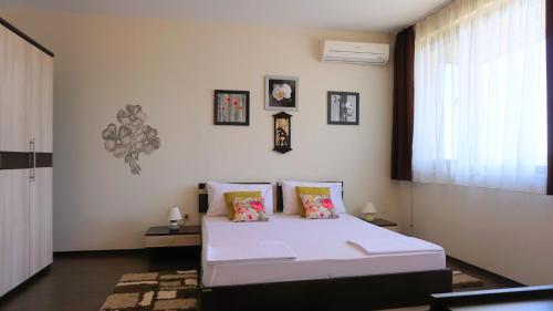 a bedroom with a white bed and a window at Вила Силва - Villa Silva in Bŭlgarevo