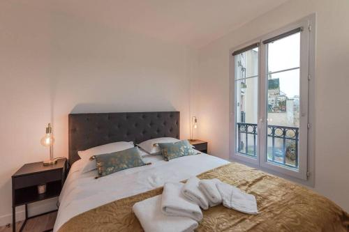 Un dormitorio con una cama grande con toallas. en Arty Paris apartment Disneyland, en Magny-le-Hongre