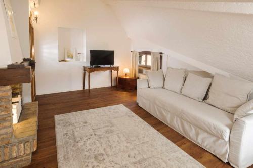 a living room with a white couch and a television at Villa Mery, sui colli della riviera di Rimini in Mondaino