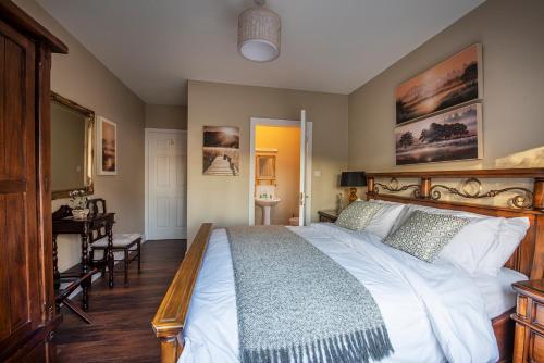 a bedroom with a large bed and a table at Arden Bungalow in Baltray