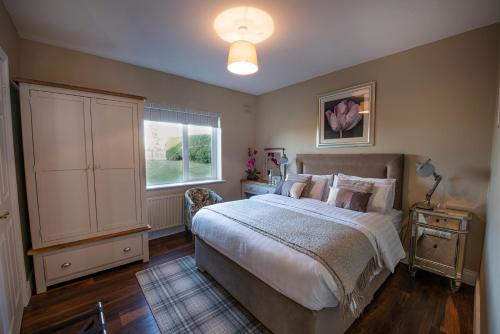 a bedroom with a large bed and a window at Arden Bungalow in Baltray