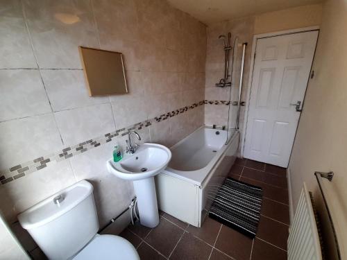 a bathroom with a toilet and a sink and a tub at Kingswood House in Nottingham